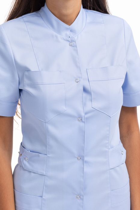 Tunika medyczna damska Kamila – fason do połowy uda, z paskiem w talii, czterema kieszeniami, stójką i mankietami na rękawach.